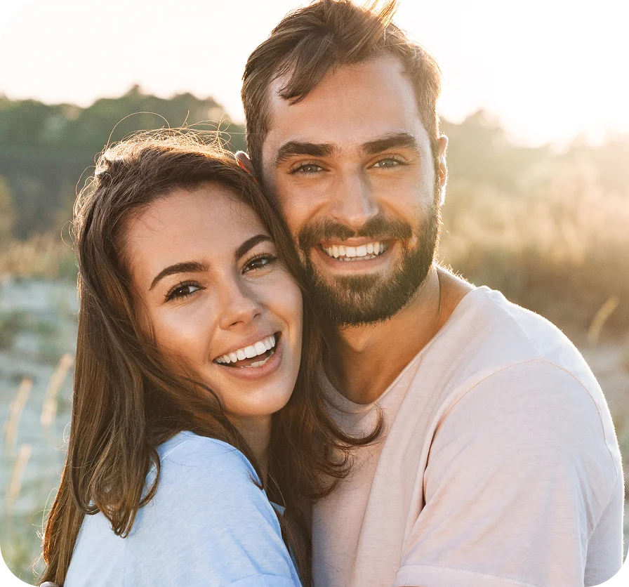 Happy couple smiling outdoors at sunset by the water in casual white clothing - Marathon in Los Angeles, CA