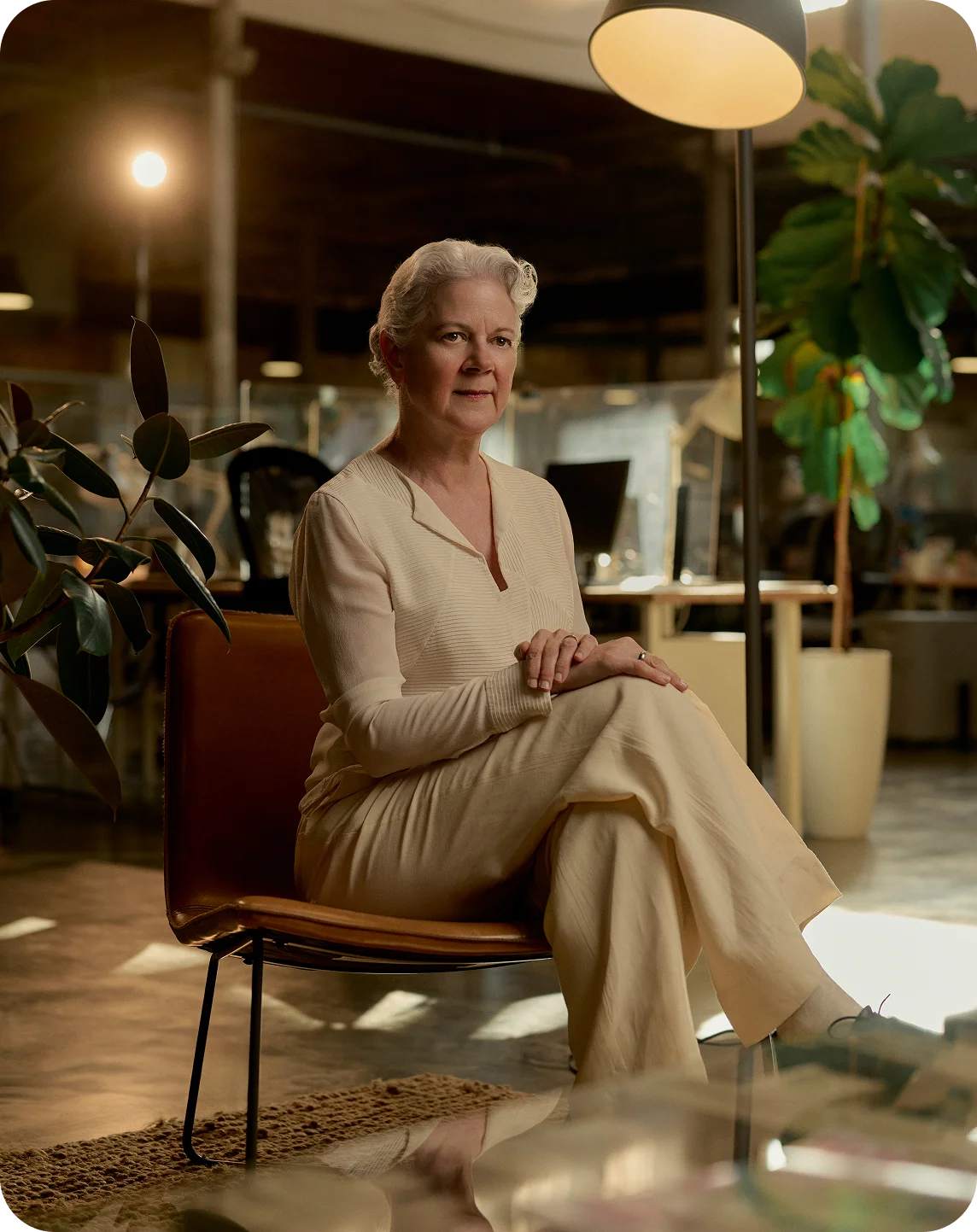 Alex Szablya MA, LMHC in beige outfit sitting on leather chair in modern illuminated interior space - In Los Angeles, CA
