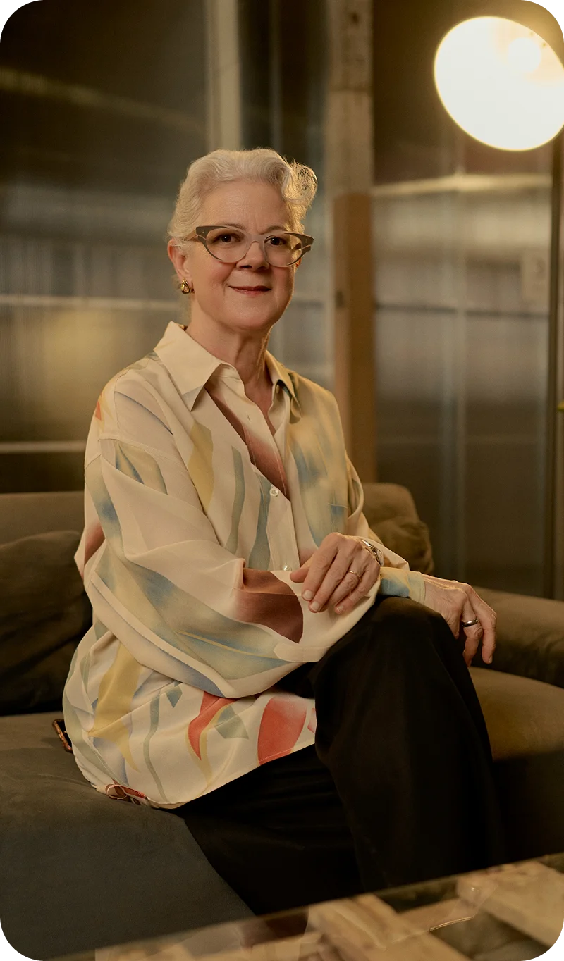 Alex Szablya MA, LMHC with short gray hair and glasses smiling while seated in modern office setting - In Los Angeles, CA