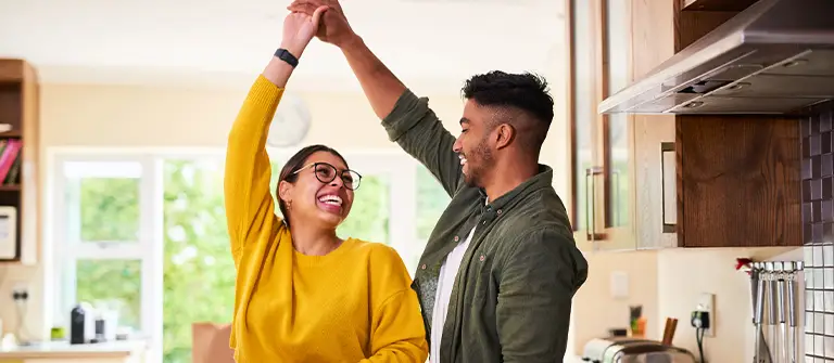 Happy couple dancing together in modern kitchen while cooking at home - Gottman in Los Angeles, CA